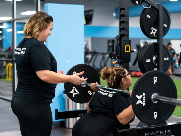 Two women working out together and spotting each other